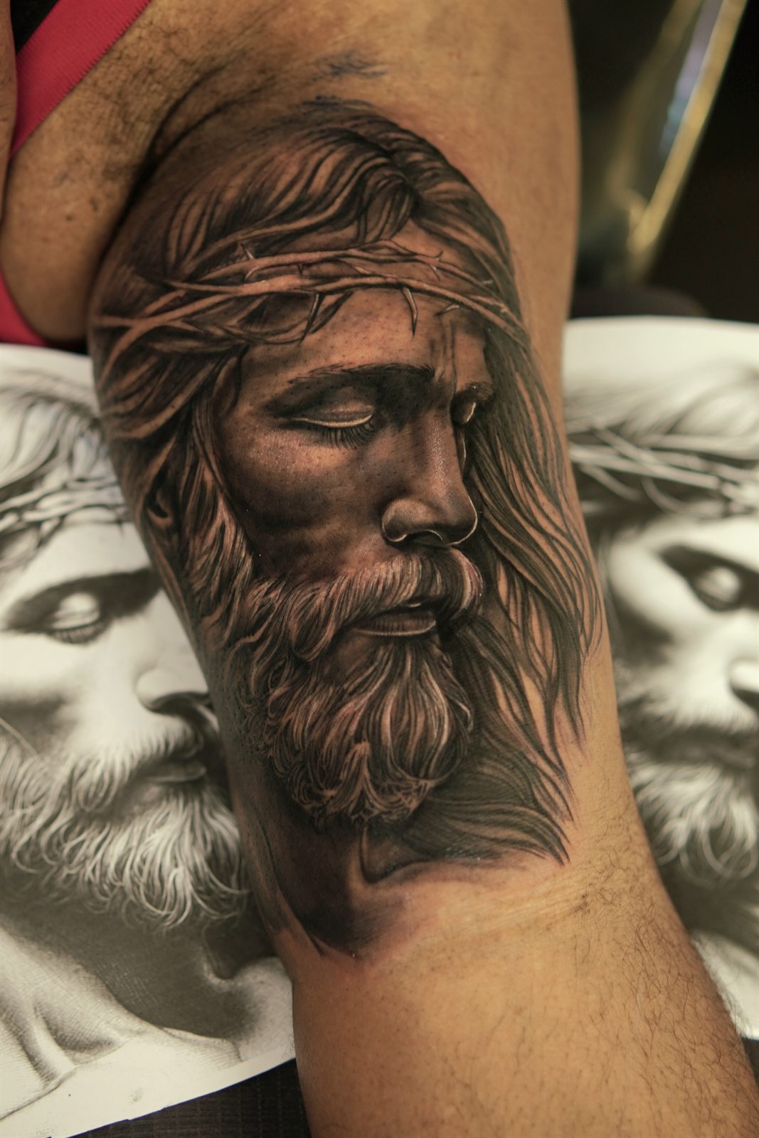 Realistic tattoo of the face of Christ statue